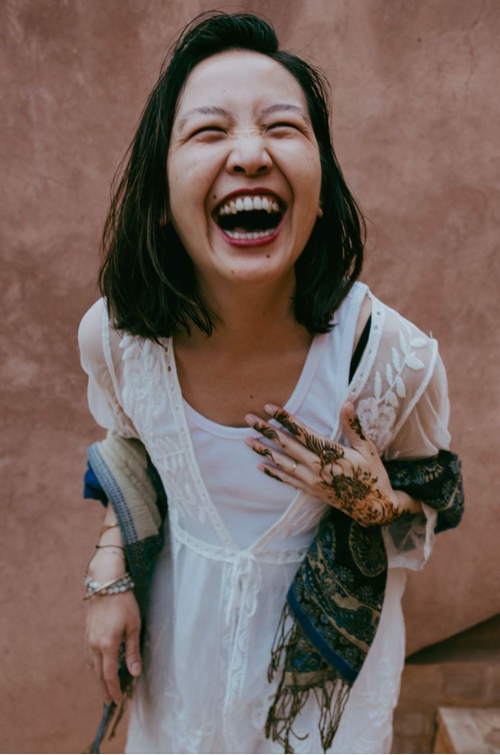 Laughter and henna against a terracotta wall