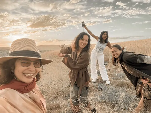 Friends laughing together in the golden field at sunset